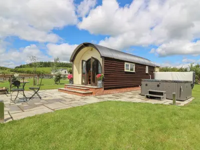 a small cabin with a grill in a yard at Woodland View in Saint Harmon