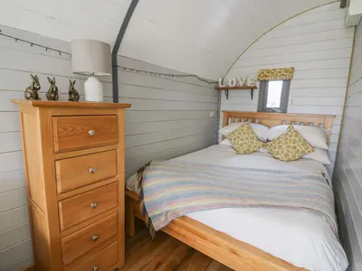 a small bedroom with a bed and a dresser at Woodland View in Saint Harmon