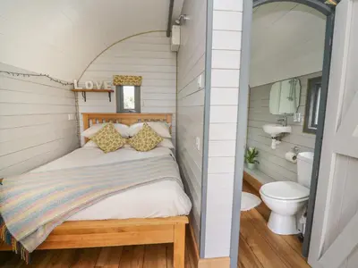 a small bedroom with a bed and a toilet at Woodland View in Saint Harmon