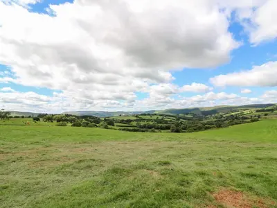 a field with green grass and a cloudy sky at Mountain View in Saint Harmon