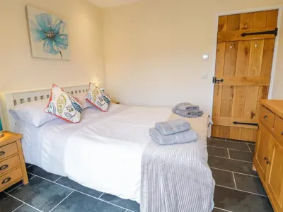 a bedroom with a white bed and a wooden cabinet at Bothi in Bala