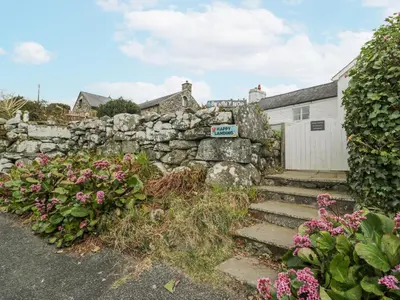 a stone wall and stairs in front of a house at Happy Landing in Harlech
