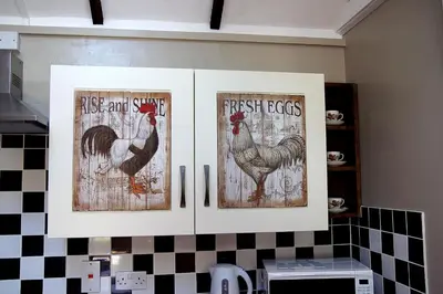 a kitchen cabinet with three pictures of chickens on it at Arrowwood Self Catering (Wagtail and Nuthatch) in Kington