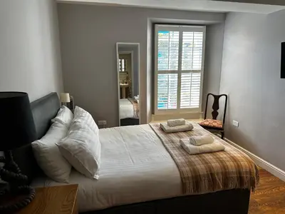 a bedroom with a large bed with two towels on it at Castle Hotel in Aberaeron