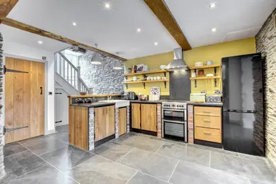 a kitchen with yellow walls and wooden cabinets at 2 Bed in Machynlleth oc-bow39 in Darowen