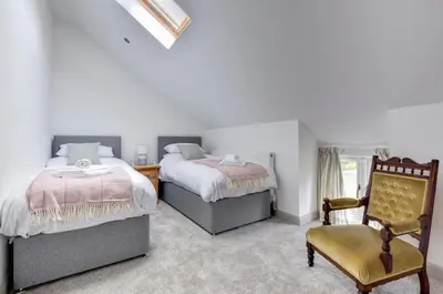 a bedroom with two beds and a chair at 5 Bed in Machynlleth oc-bow30 in Darowen