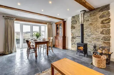 a living room with a table and a fireplace at 5 Bed in Machynlleth oc-bow30 in Darowen