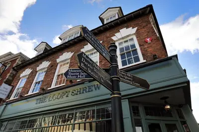 a pole with street signs in front of a building at The Loopy Shrew in Shrewsbury
