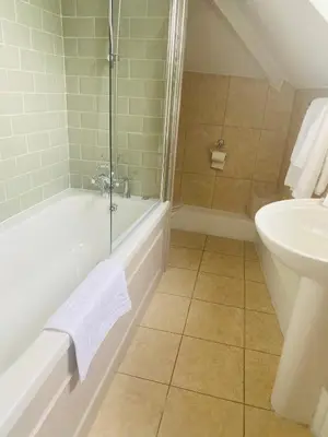 a bathroom with a shower tub and a sink at The Loopy Shrew in Shrewsbury