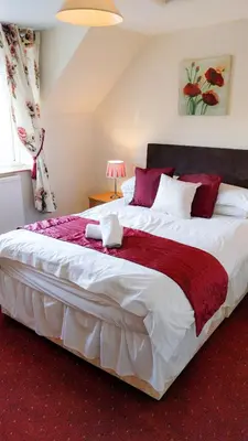 a bedroom with a large white bed with a red blanket at Seven Stars in Hay-on-Wye