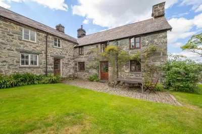 an exterior view of a stone house with a yard at 3 Bed in Dolgellau oc-wah569 in Llanfachreth