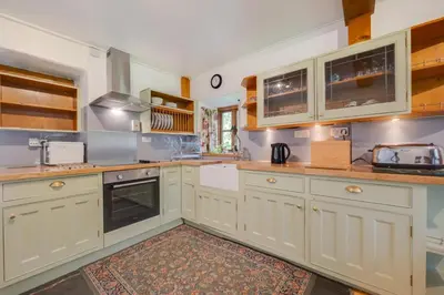 a large kitchen with white cabinets and appliances at 3 Bed in Dolgellau oc-wah569 in Llanfachreth