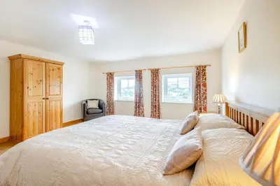 a bedroom with a large bed and two windows at 3 Bed in Bala oc-waf247 in Bettws Gwerfil Goch
