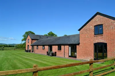 a red brick building with a wooden fence at 2 Bed in Llandinam oc-waa377 in Llandinam