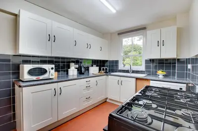 a kitchen with white cabinets and a stove top oven at 6 Bed in Dolgellau oc-wah675 in Arthog
