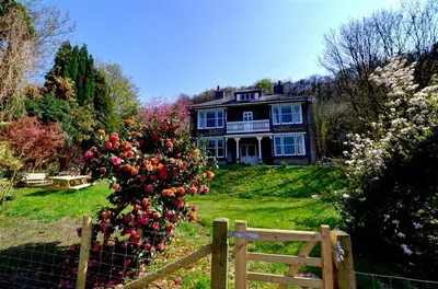 a house with a fence and a bush of flowers at 6 Bed in Dolgellau oc-wah675 in Arthog