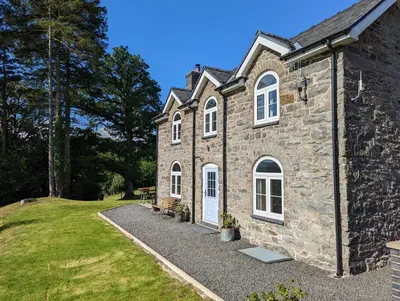 a stone house with white windows and a yard at 3 Bed in Llangadfan oc-wae284 in Llangadfan