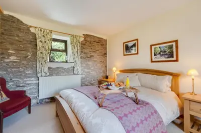 a bedroom with a large bed and a table at Bryncylla in Llangurig