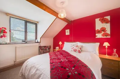 a bedroom with red walls and a large bed at Bryncylla in Llangurig