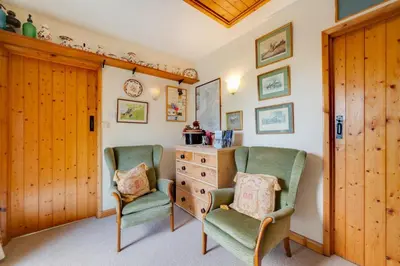 two chairs and a dresser in a room at Bryncylla in Llangurig