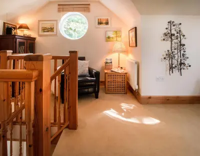 a living room with a chair and a window at Berries Coach House in Church Stretton