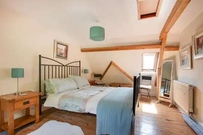 a bedroom with a bed and a wooden floor at 4 Bed in Barmouth oc-wah585 in Penmaenpool