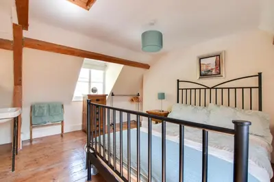 a bedroom with a large bed and a staircase at 4 Bed in Barmouth oc-wah585 in Penmaenpool