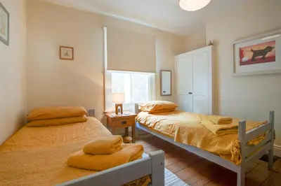 a bedroom with two beds and a window at 4 Bed in Barmouth oc-wah585 in Penmaenpool