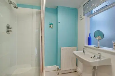 a bathroom with a shower and a sink and a mirror at 4 Bed in Barmouth oc-wah585 in Penmaenpool