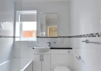 a white bathroom with a sink and a toilet at Tredegar in Dyffryn
