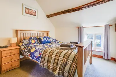 a bedroom with a bed and a dresser and a window at 3 Bed in Dolgellau oc-wah605 in Rhydymain