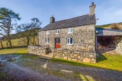 an old stone house with a red door at 3 Bed in Dolgellau oc-wah605 in Rhydymain