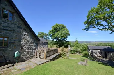 an exterior view of a stone house with a yard at 4 Bed in Dolgellau oc-wah568 in Llanfachreth