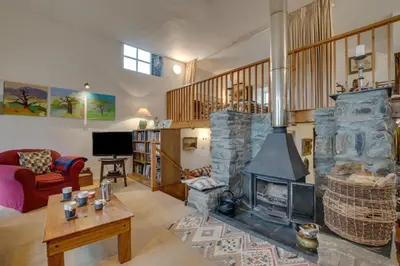 a living room with a large stone fireplace at 3 Bed in Dolgellau oc-wah484 in Llanfachreth