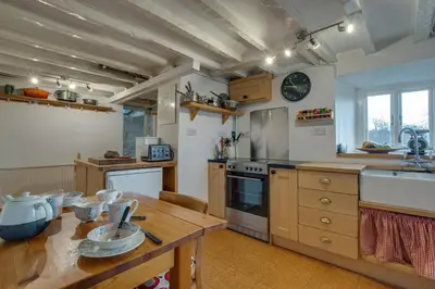 a kitchen with a wooden table and a counter top at 3 Bed in Dolgellau oc-wah484 in Llanfachreth