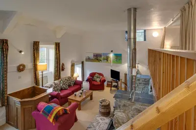 a living room with red chairs and a fireplace at 3 Bed in Dolgellau oc-wah484 in Llanfachreth