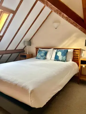 a bedroom with a large white bed with blue pillows at The Beacons Guest House in Brecon