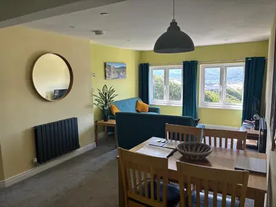a living room with a table and a blue couch at Bryn Melyn Apartments in Barmouth