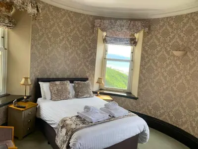 a bedroom with a bed with towels on it at Tyr Graig Castle in Barmouth