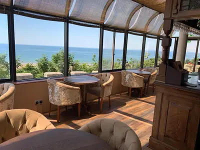 a dining room with tables and chairs and windows at Tyr Graig Castle in Barmouth