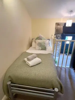 a bedroom with a bed with two towels on it at Dolgun Uchaf Historic B&B and Cottages with Boutique Bedrooms In The Heart of Snowdonia in Dolgellau
