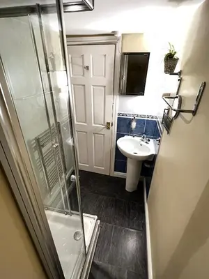 a bathroom with a shower and a sink at Dolgun Uchaf Historic B&B and Cottages with Boutique Bedrooms In The Heart of Snowdonia in Dolgellau