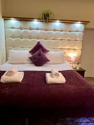 a bedroom with a large bed with towels on it at Dolgun Uchaf Historic B&B and Cottages with Boutique Bedrooms In The Heart of Snowdonia in Dolgellau
