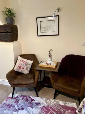 two chairs and a table in a room with a table and chairs at Dolgun Uchaf Historic B&B and Cottages with Boutique Bedrooms In The Heart of Snowdonia in Dolgellau