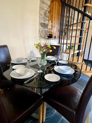 a black dining room table with black chairs and a black table with glasses at Dolgun Uchaf Historic B&B and Cottages with Boutique Bedrooms In The Heart of Snowdonia in Dolgellau