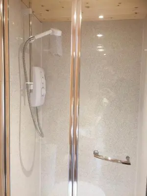 a shower with a glass door in a bathroom at Romantic Getaway Luxury Wooden Cabin With Private Hot Tub and BBQ in Aberystwyth