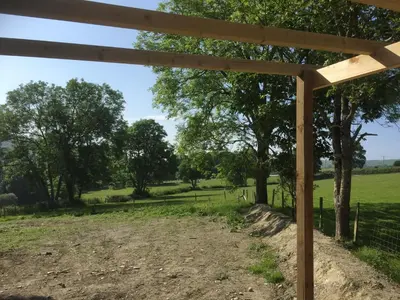 a wooden pergola in a field with trees at Romantic Getaway Luxury Wooden Cabin With Private Hot Tub and BBQ in Aberystwyth