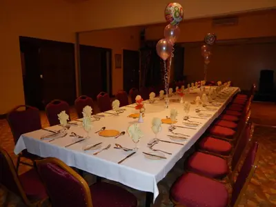 a long table in a room with red chairs at Burton Hotel in Kington