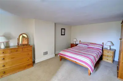 a bedroom with a bed and a dresser and a mirror at 4 Bed in Presteigne oc-wak235 in Norton