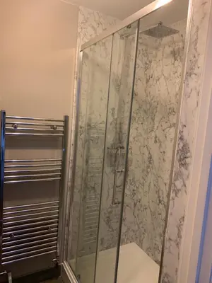 a shower with a glass door in a bathroom at Victorian Church Flat 3 in Oswestry